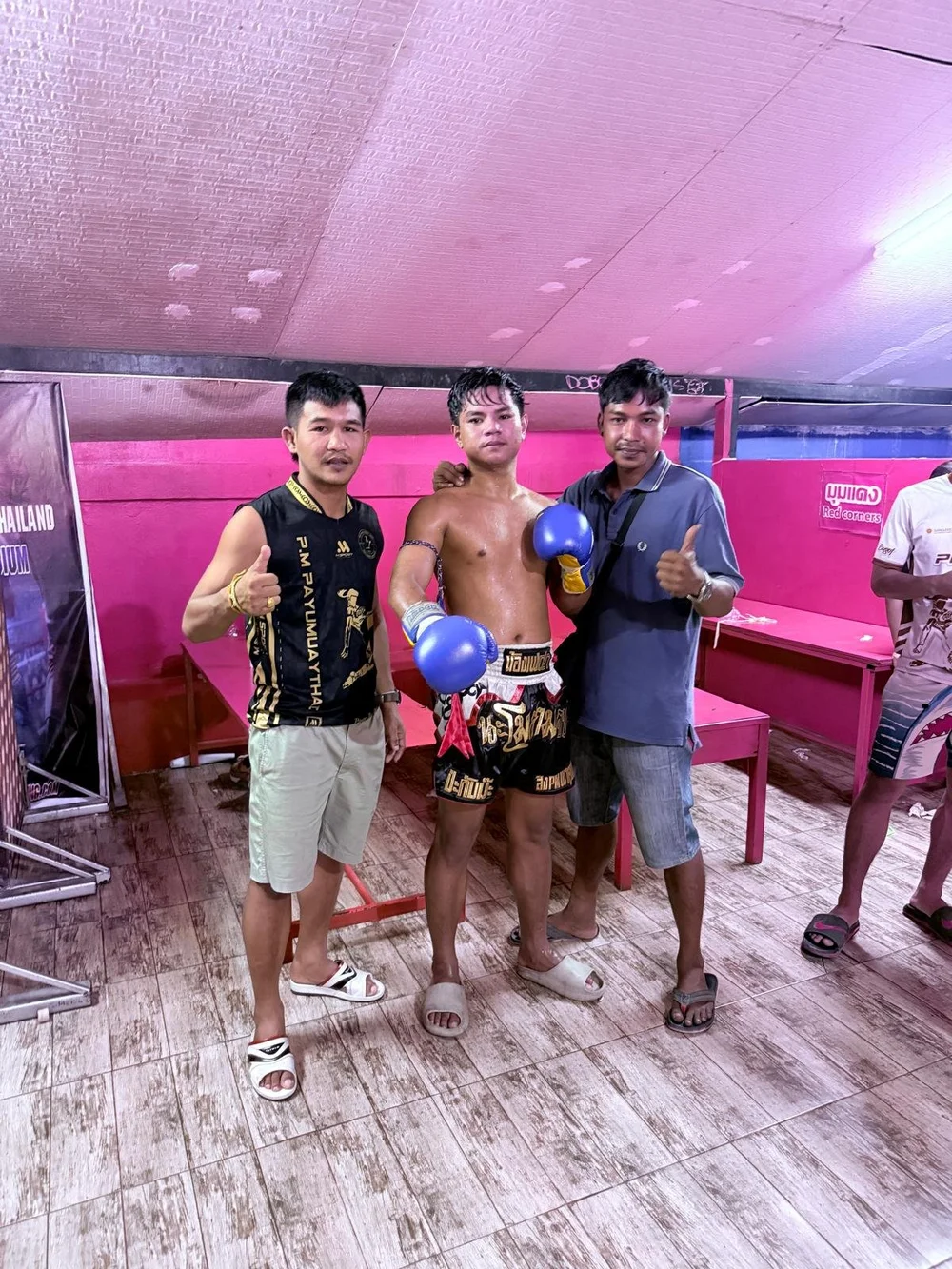 Gym team celebrating with a young fighter in the ring after a win