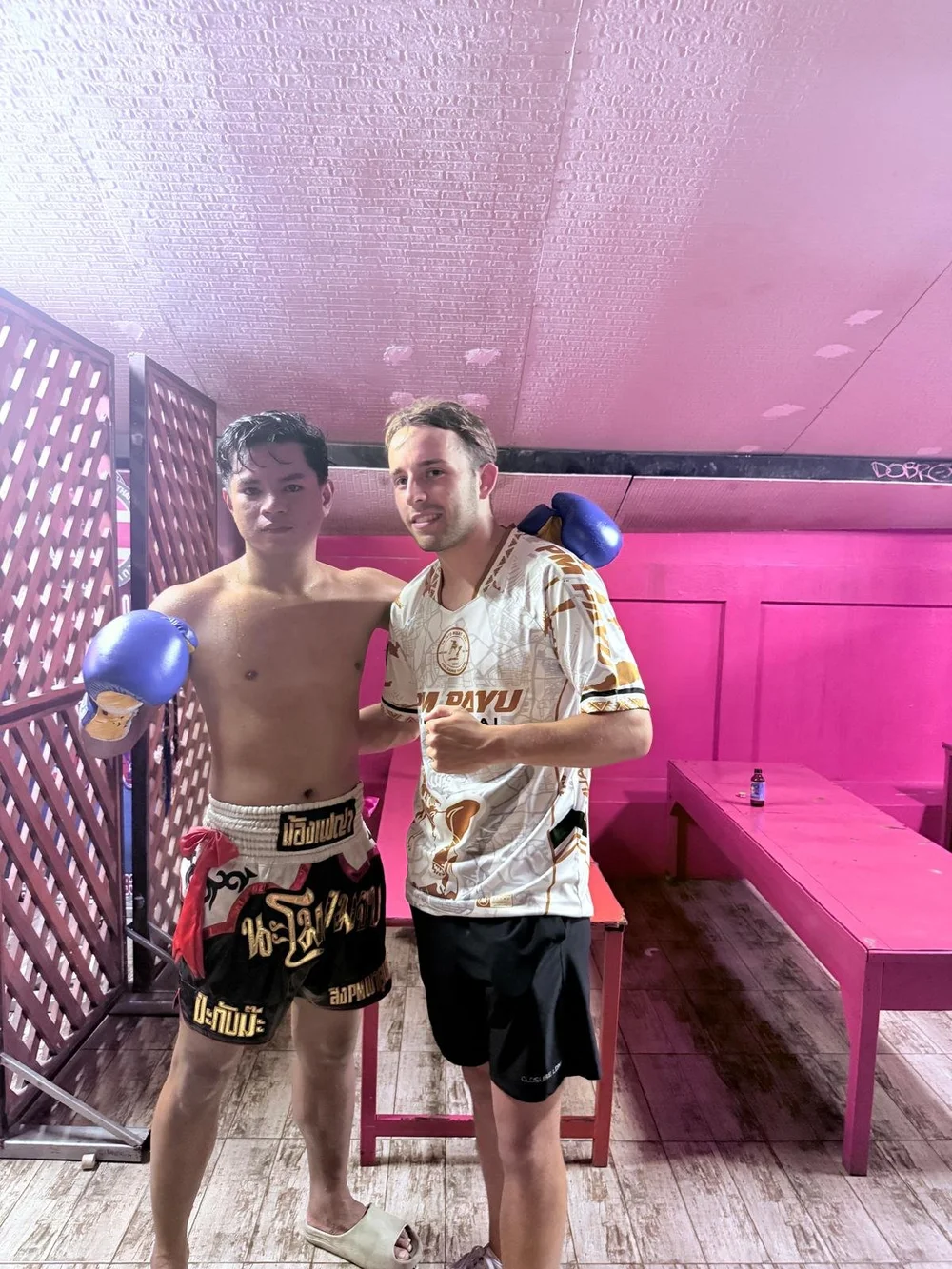 Fighter posing with teammates after a bout at Samui International Stadium