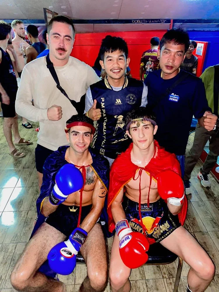Two fighters with coaches after a bout at Samui International Stadium