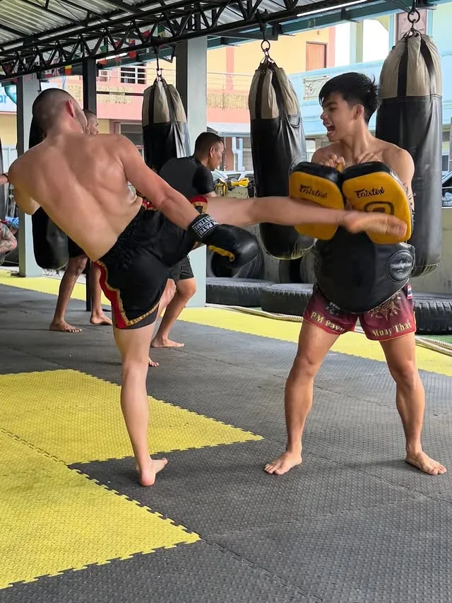 Kru Arm holding pads during training