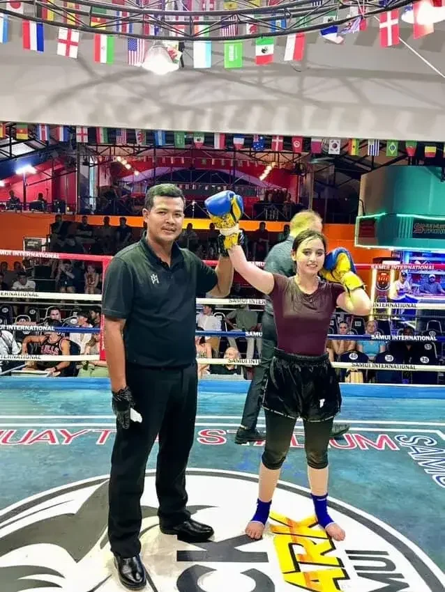 Female fighter with raised glove after a win at Samui International Stadium