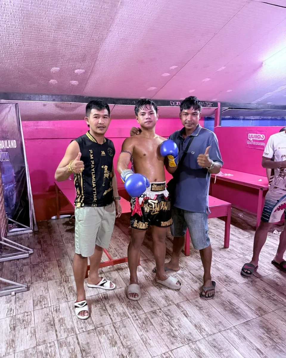 Gym team celebrating with a young fighter in the ring after a win