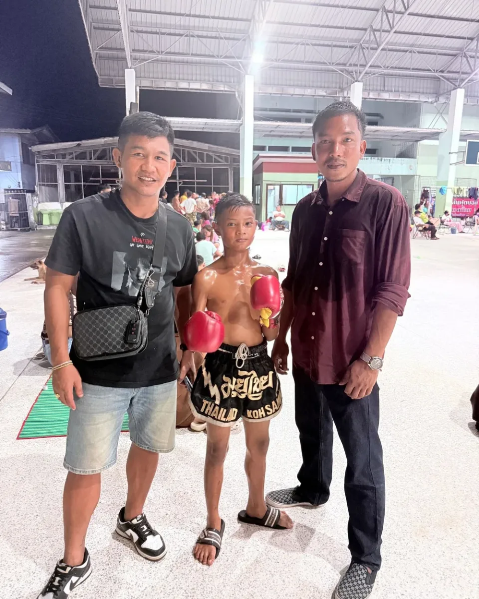 Young fighter posing with coaches after a win