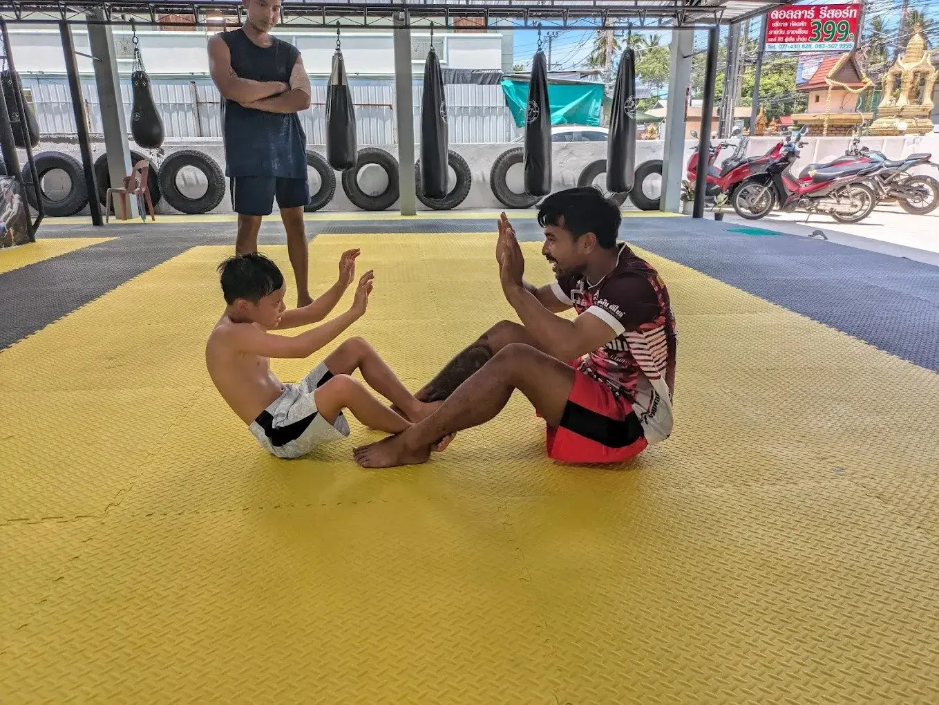 Coach leading kids crunches on the mat at PM PAYU, Koh Samui