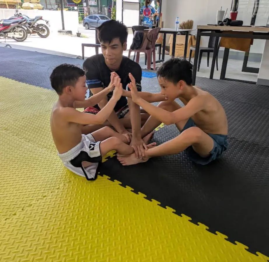 Woman doing pad work with a coach at PM PAYU Muay Thai, Koh Samui