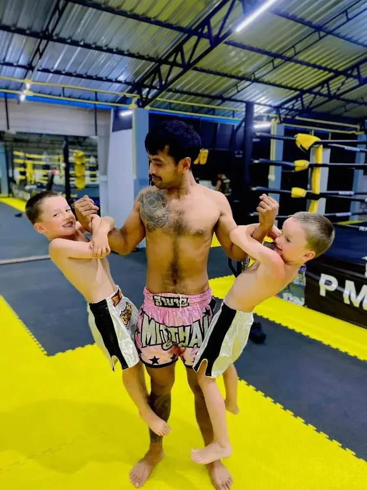 Kru Kong lifting two kids after class at PM PAYU Muay Thai, Koh Samui