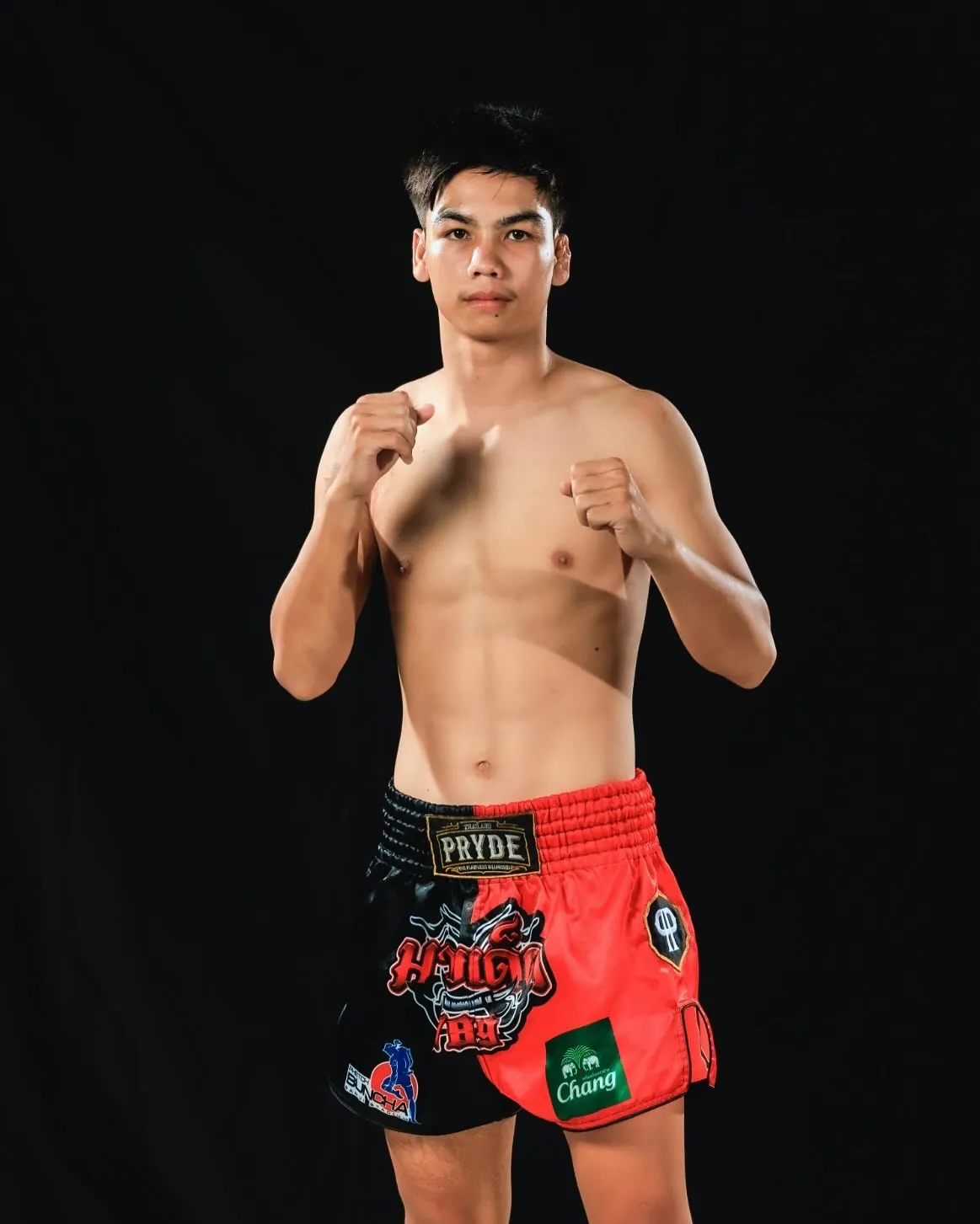 Kru Arm in fighting stance on a studio backdrop