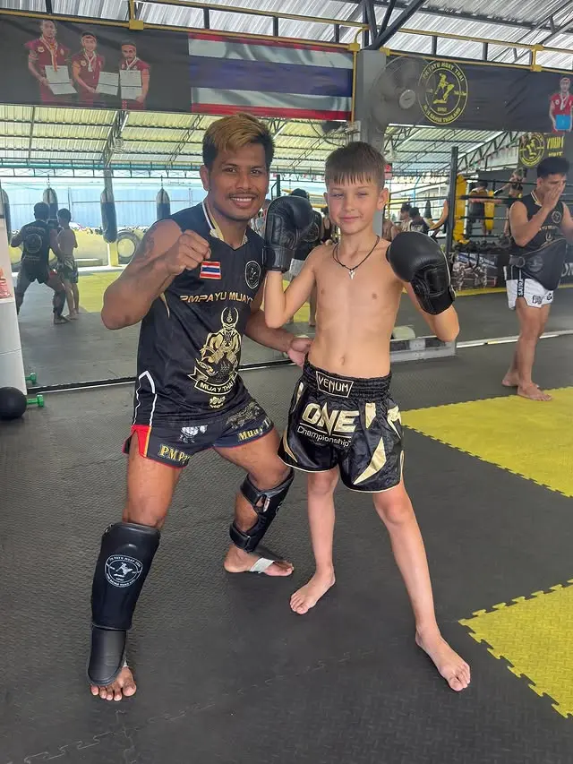 Kru Koban posing with a young student at PM PAYU Muay Thai, Koh Samui