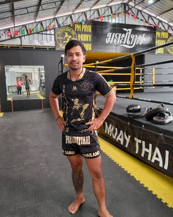 Kru Kong smiling with fists raised at PM PAYU Muaythai, Koh Samui